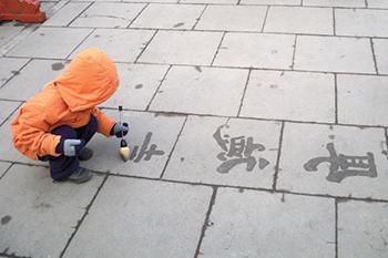 一个孩子在人行道上写字.
